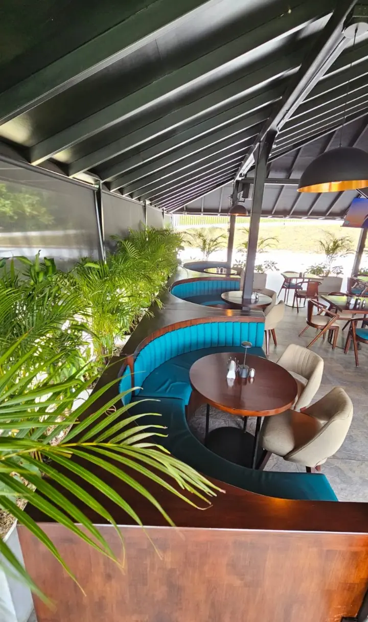 Restaurante del hospedaje con vegetación y mobiliario moderno